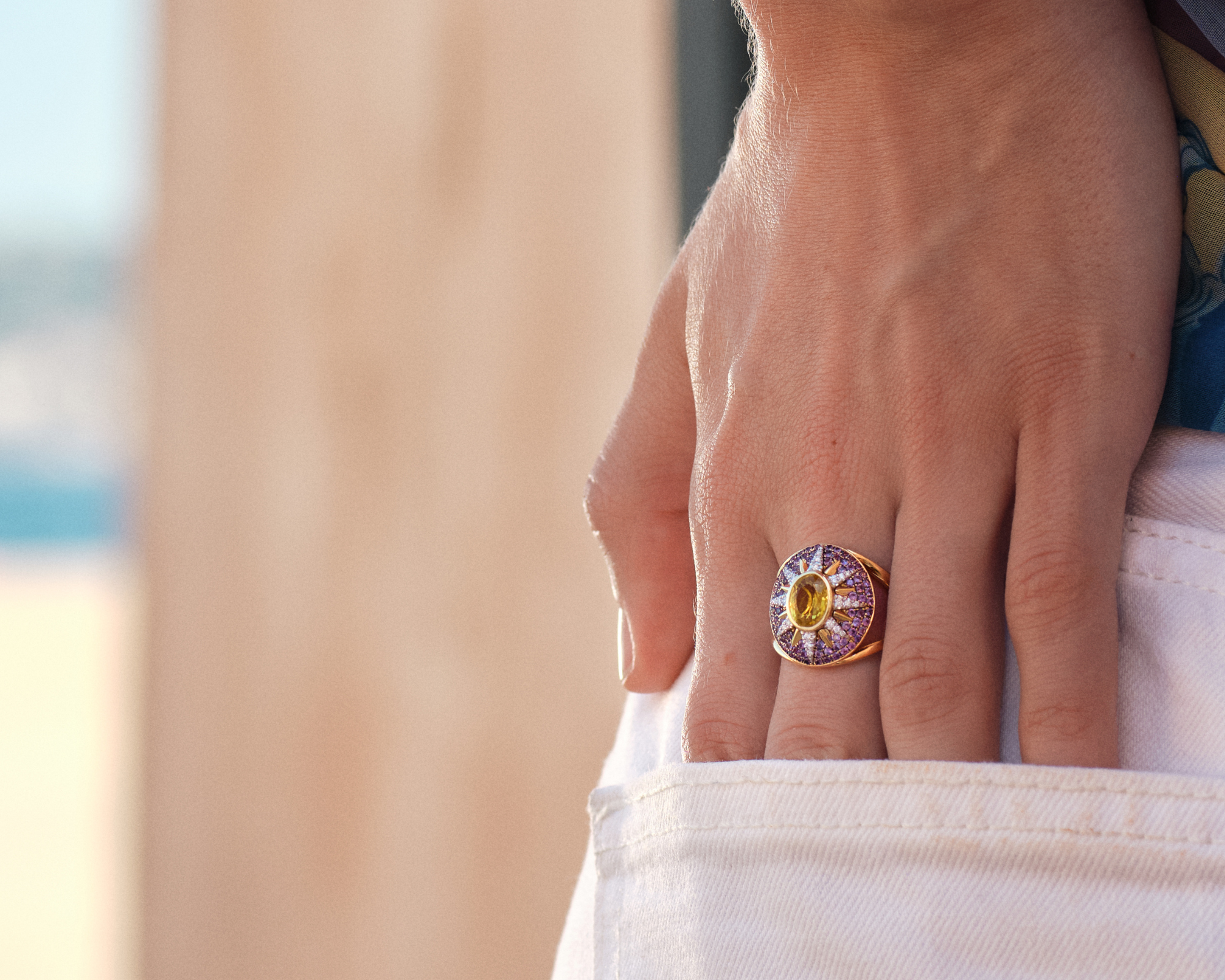Yellow sapphire and blue tanzanite Crush Nova ring in 18k gold with star motif on woman's hand